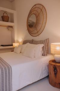 a bedroom with a white bed with a mirror on the wall at Herdade D’ Amoreira Aljezur in Aljezur +100 photos