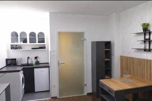 a kitchen with white walls and a yellow door at Midnight Crown Suite in Hannover