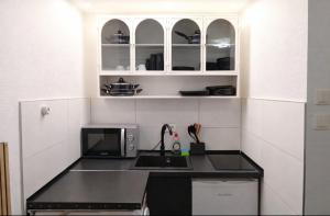 a small kitchen with a sink and a microwave at Midnight Crown Suite in Hannover +5 photos