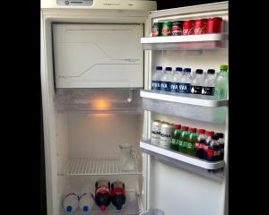 an open refrigerator filled with lots of drinks and sodas at Apartamento Central in Passos