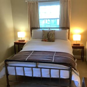 a bedroom with a large bed with two lamps at The Somerton Hideaway in Somerton