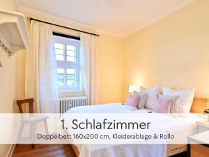 a bedroom with a white bed with a window at Amalias Altstadtquartier - Apartment mit Aufzug & Garten in der Hinterburg Schlitz - 2 Schlafzimmer, Parkplatz, Altstadtflair für Paare & Ruhesuchende in Schlitz