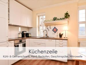 a kitchen with white cabinets and a kitchen sink at Amalias Burgwohnung - stilvolles Apartment mit Aufzug & Garten in der Hinterburg Schlitz - 2 Schlafzimmer, Parkplatz, Historisches Flair für Paare & Ruhesuchende in Schlitz +53 photos