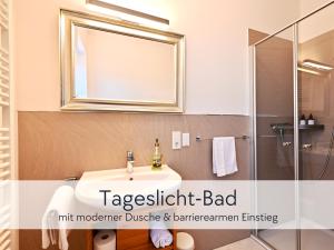a bathroom with a sink and a mirror at Amalias Altstadtquartier - Apartment mit Aufzug & Garten in der Hinterburg Schlitz - 2 Schlafzimmer, Parkplatz, Altstadtflair für Paare & Ruhesuchende in Schlitz