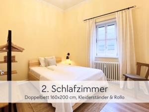 a bedroom with a bed and a window at Amalias Burgwohnung - stilvolles Apartment mit Aufzug & Garten in der Hinterburg Schlitz - 2 Schlafzimmer, Parkplatz, Historisches Flair für Paare & Ruhesuchende in Schlitz
