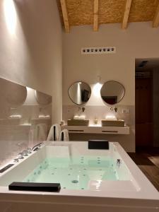 a bathroom with a large tub with two mirrors at Hotel Recanto do Avia in Ribadavia +38 photos