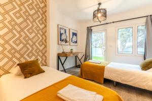 a room with two beds and a window at Carregado First Floor in Carregado