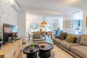 a living room with a couch and a dining room at Carregado First Floor in Carregado