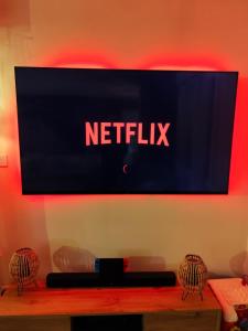 a television screen with the netflix sign on a wall at Maison proche du Circuit 24h du Mans, Moto GP, Le Mans Classic in Neuville-sur-Sarthe