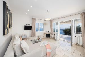 a living room with a white couch and a view of the ocean at Villa Nefeli in Apergátika