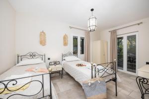 a bedroom with two beds and a window at Villa Nefeli in Apergátika +42 photos