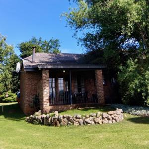 a small brick house with a stone wall at Dunford's Loft in Himeville
