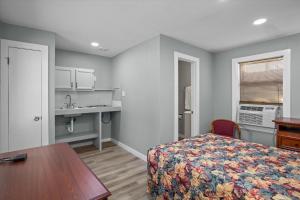 a bedroom with a bed and a table and a sink at Angelina Motel in Lufkin