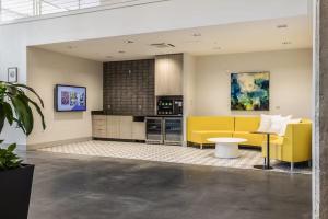 a kitchen with a yellow couch and a table at Cincinnati Downtown Oasis in Cincinnati