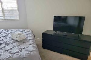 a bedroom with a dresser with a large tv on it at Cincinnati Downtown Oasis in Cincinnati