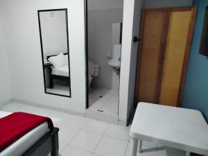 a bathroom with a mirror and a bed and a sink at Hotel Galerias in Ruiosucio