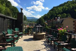 a patio with green chairs and tables and a fountain at Baymont by Wyndham Gatlinburg On The River in Gatlinburg