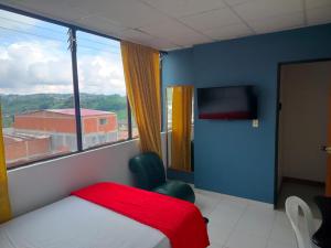 a bedroom with a bed and a large window at Hotel Galerias in Ruiosucio