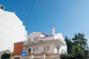 a white building with a balcony on top of it at Carregado First Floor in Carregado