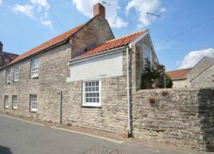 an old brick building with a red roof at The Somerton Hideaway in Somerton