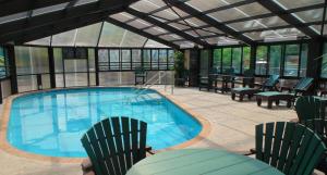 uma piscina com duas cadeiras e uma mesa e cadeiras em Baymont by Wyndham Gatlinburg On The River em Gatlinburg