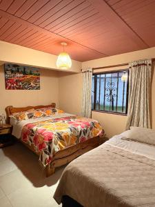 a bedroom with two beds and a window at Hotel Casa Grande in Tibirita