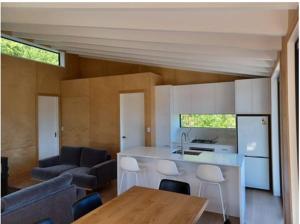a kitchen and living room with a couch and a table at Ponga House - Kaitoke Waters in Okupu