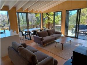 a living room with a couch and a table at Ponga House - Kaitoke Waters in Okupu +8 photos