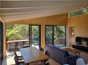 a living room with a couch and a table at Ponga House - Kaitoke Waters in Okupu