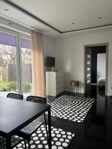 a living room with a table and chairs and a window at Różana City Apartaments in Kutno +30 photos