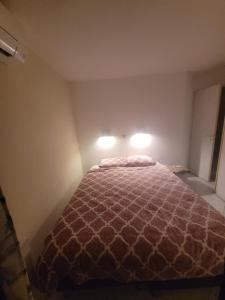 a bedroom with a bed with two lights on it at Chambres charmantes dans un appartement moderne à deux pas de la mer in Cannes +2 photos