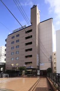 a large building in front of a building at Shinmatsudo Station Hotel in Matsudo