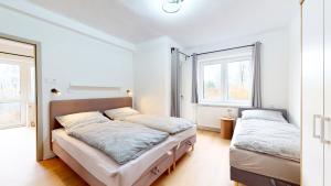 a bedroom with two beds and two windows at Villa Montis in Deštné v Orlických horách