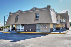 un grand bâtiment avec un panneau sur son côté dans l'établissement Sunset Inn, à Jacksonville