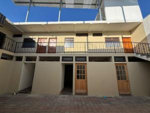 an apartment building with a balcony and doors at Hotel El Alero in Chimaltenango