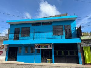 a blue building with a balcony at Hotel El Alero in Chimaltenango