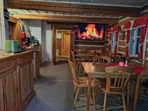 a restaurant with wooden tables and a tv on the wall at Rodinný penzion Míša in Velká Úpa