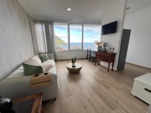 a living room with a couch and a table at Feeling Like Home Machico in Machico