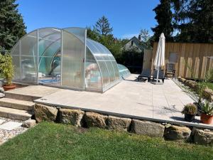 uma casa de vidro com uma piscina num quintal em Ferienhaus CaroGrün in Erfurt-gemütlich-sonnig-Küche-Bad-Garten-Parken-Pool-Sauna-WLAN em Erfurt