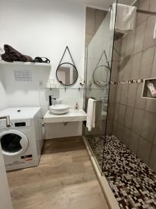 a bathroom with a shower and a washing machine at Feeling Like Home Machico in Machico +33 photos