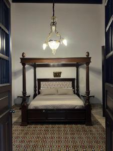 a bedroom with a bed with a chandelier above it at Hotelito DELI in Mérida +84 photos