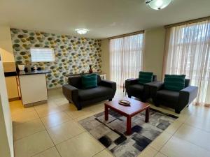 a living room with two chairs and a table at Oceanic 2 Bedroom Apartment - Ocean and Park View - Self-Catering in Durban