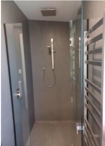 a shower stall in a bathroom with a glass door at Ponga House - Kaitoke Waters in Okupu