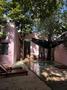 a house with a swimming pool and a tree at Hotelito DELI in Mérida