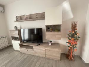 een woonkamer met een groot entertainmentcentrum met een televisie bij Pino s house in Inveruno