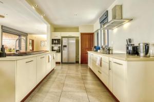a large kitchen with white cabinets and appliances at Comme un bateau sur l'océan in Saint-Leu