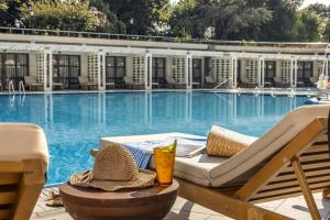 a swimming pool with a lounge chair and a drink at Hilton Istanbul Bosphorus in Istanbul +211 photos