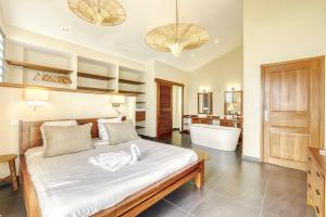 a bedroom with a bed with a tub and a bathroom at Comme un bateau sur l'océan in Saint-Leu
