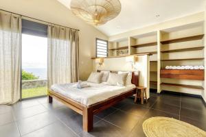 a bedroom with a bed and a large window at Comme un bateau sur l'océan in Saint-Leu +16 photos