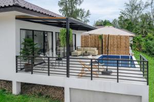a deck with a pool and patio furniture at Zen Beach Lake Villa 3 - orchid villa in Haad Chao Phao